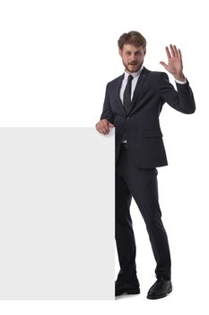 Young business man in suit with banner for your text isolated on white background