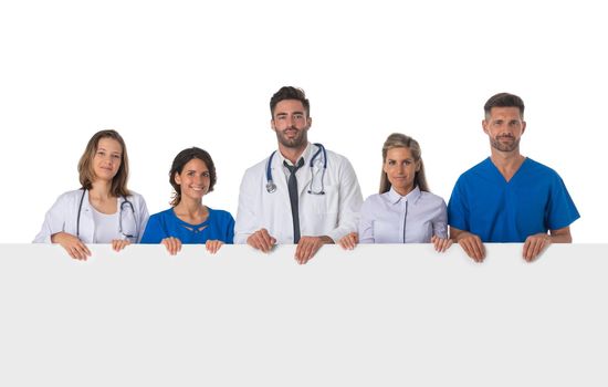 Group of doctors with blank banner isolated over a white background