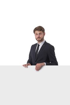 Young serious business man showing blank signboard, isolated over white background