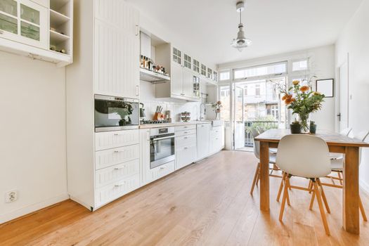 Adorable large kitchen area with white wooden cabinets