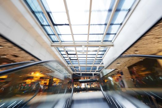 Shopping mall center escalators. Zoom blur movement.