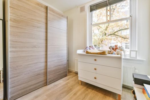 Adorable room with a window overlooking the street and a large wooden wardrobe