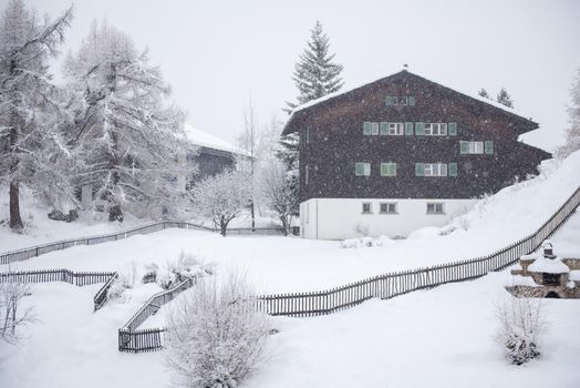 beautiful winter landscape with a mountain house in snowstorm