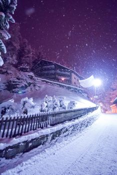 a view on snowy streets of the Alpine mountain village in the cold winter night