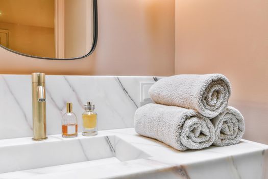 Luxurious washroom with peach walls and marble top and sink