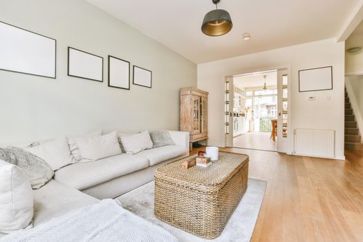 Adorable living room with large soft sofa and wicker coffee table