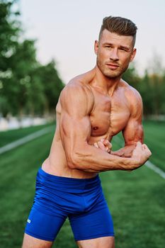 man with pumped up muscular body outdoors health workout. High quality photo