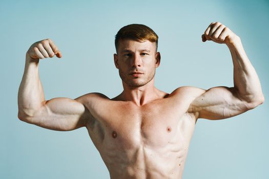 bodybuilder with muscular body posing press blue background. High quality photo