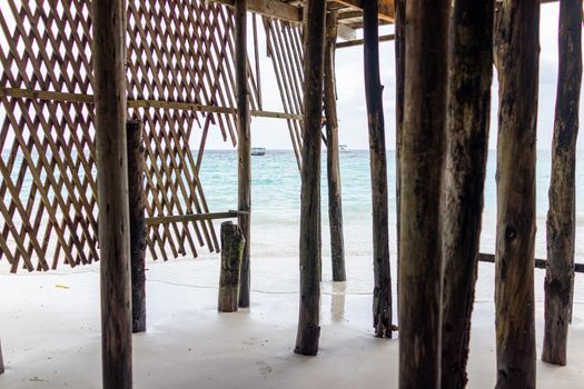 Wooden pillars on ocean shore into blue water with no people