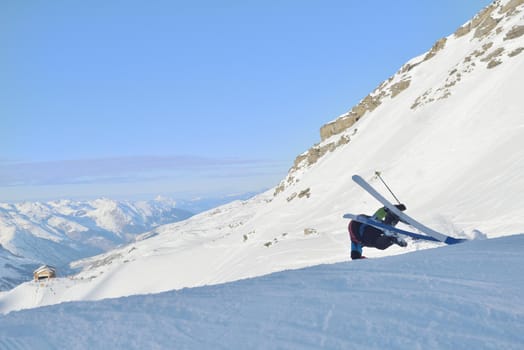 jumping freestyle skier at mountain with fresh snow fresh sunny winter day