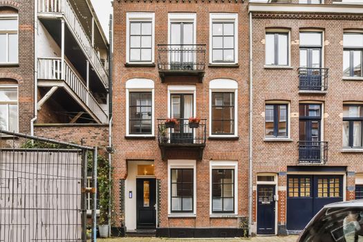 Luxurious two-story brick building with black balconies and doors