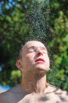 young man relaxing under shower