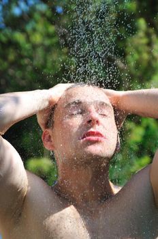 young man relaxing under shower