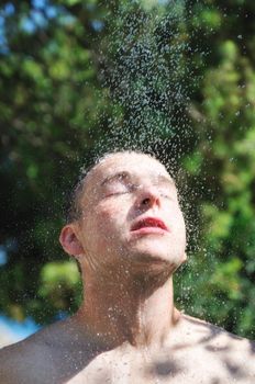 man wash head under shower with falling water