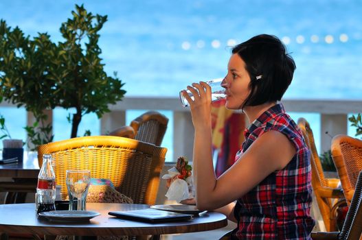 Young lady having dinner by the sea