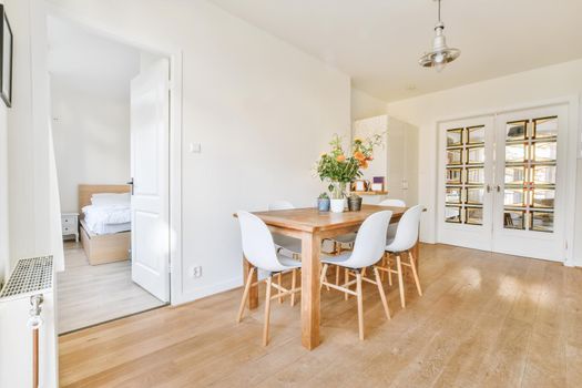 Adorable large dining room with wooden table and door leading to the bedroom