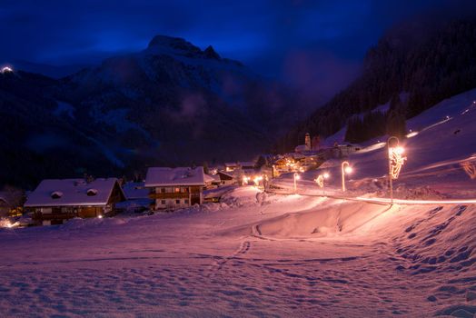 mountain village in alps  at night in winte  with fresh snow