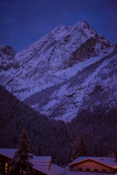 mountain village in alps  at night in winte  with fresh snow