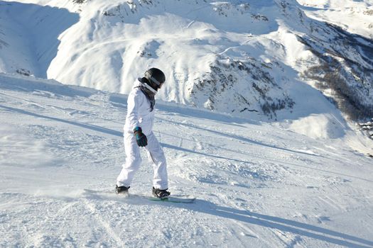 skier skiing downhill on fresh powder snow  with sun and mountains in background