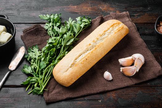 Ingredients for sandwich with butter, herbs and baguette set, on old dark wooden table background