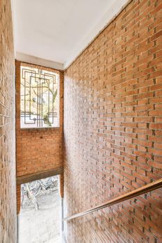 Adorable top view of the staircase of a building with a window with a lattice