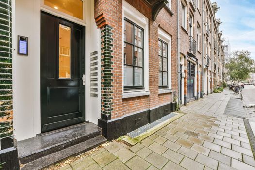 Luxurious two-story brick building with black balconies and doors