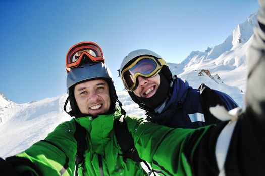 happy people group have fun on ski snow at winter season on mountain with blue sky and fresh air