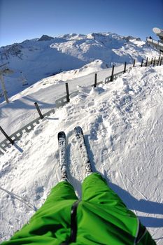 skier skiing downhill on fresh powder snow  with sun and mountains in background