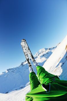 skier skiing downhill on fresh powder snow  with sun and mountains in background