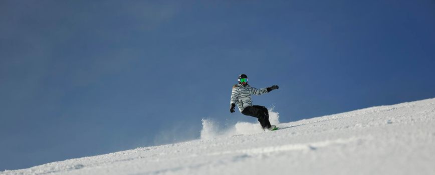 snowboard woman racing downhill slope and freeride on powder snow at winter season and sunny day