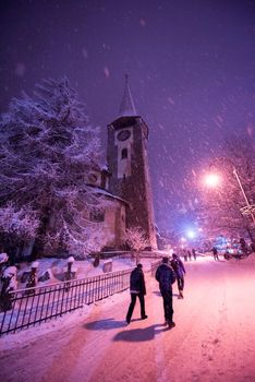 a view on snowy streets of the Alpine mountain village in the cold winter night