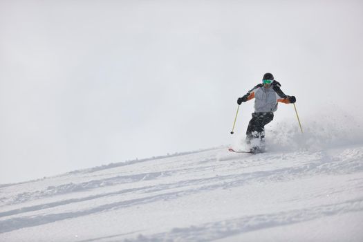 man ski free ride downhill at winter season on beautiful sunny day and powder snow