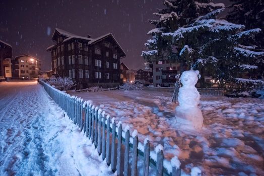 a view on snowy streets of the Alpine mountain village in the cold winter night