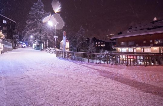 a view on snowy streets of the Alpine mountain village in the cold winter night