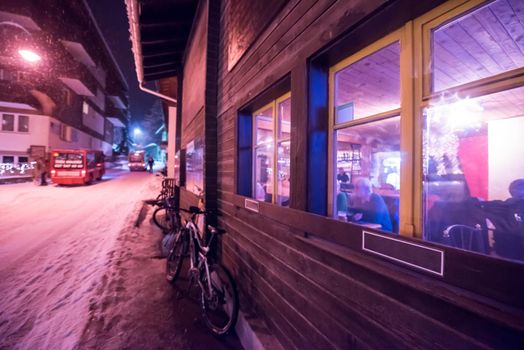 a view on snowy streets of the Alpine mountain village in the cold winter night