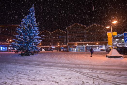 a view on snowy streets of the Alpine mountain village in the cold winter night