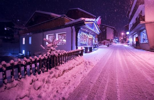 a view on snowy streets of the Alpine mountain village in the cold winter night