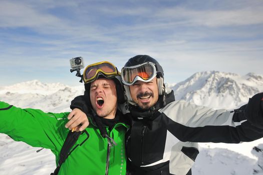 happy people group have fun on snow at winter season on mountain with blue sky and fresh air