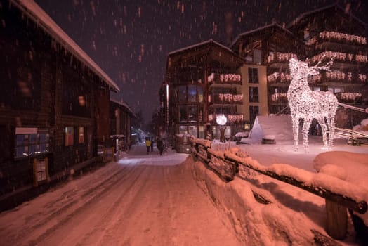 a view on snowy streets of the Alpine mountain village in the cold winter night