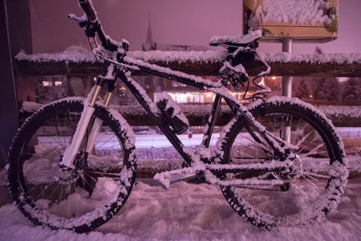 end of biking season.parked bicycle covered by snow from a heavy snowstorm.Winter cycling