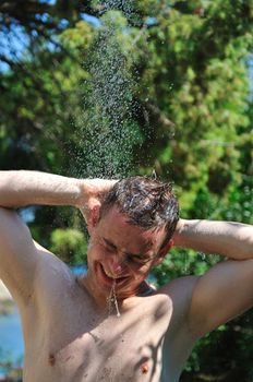 young man relaxing under shower