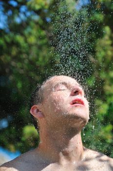 young man relaxing under shower