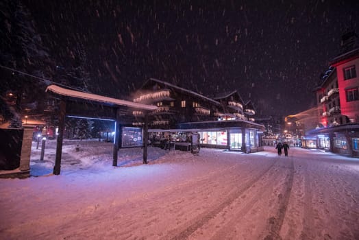 a view on snowy streets of the Alpine mountain village in the cold winter night