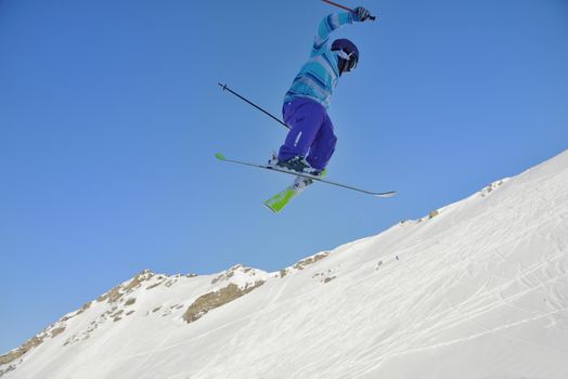 jumping freestyle skier at mountain with fresh snow fresh sunny winter day