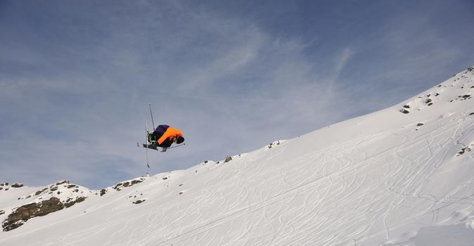 extreme freestyle ski jump with young man at mountain in snow park at winter season