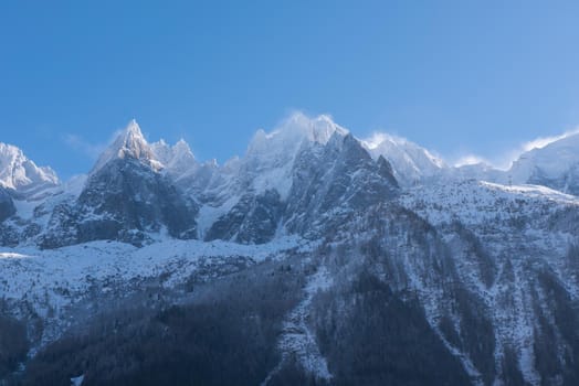 French alps mountain peaks covered with fresh snow. Winter landscape nature scene on beautiful sunny winter day.