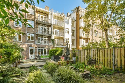 The courtyard of a multi-storey building overgrown with greenery