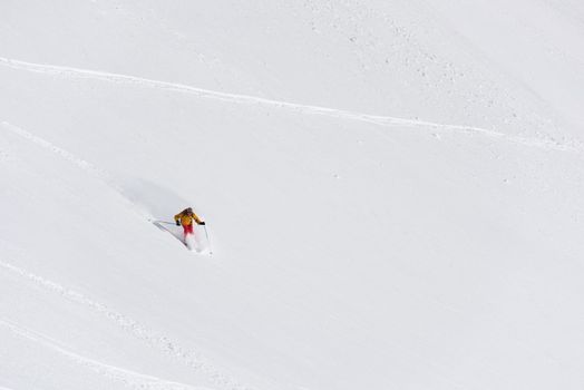 extreme freeride skier skiing on fresh powder snow in downhill at winter mountains