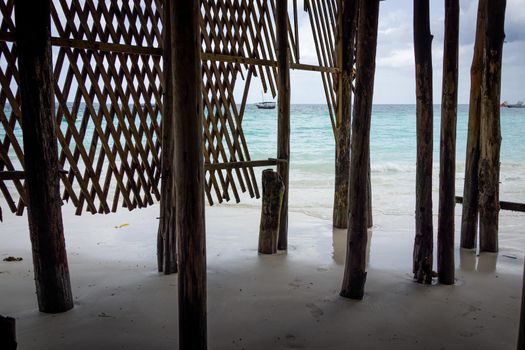 Wooden pillars on ocean shore into blue water with no people