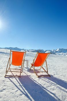 chair on top of mountain range at winter season sunny day with blue sky in background representing concept of relax